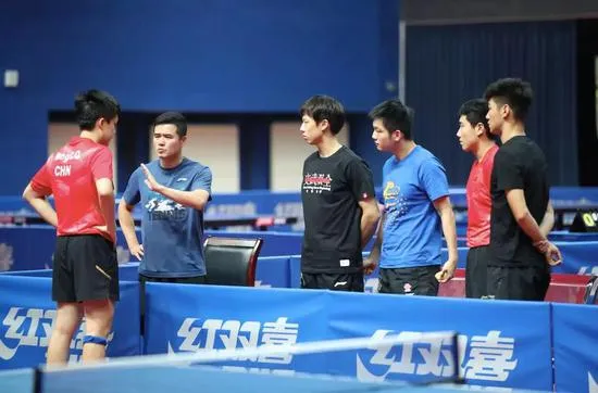 Coach Liu Guozheng talking to Wang Chuqin, with Lin Gaoyuan, Fan Zhendong, Liang Jingkun, and Xu Fei on the side.